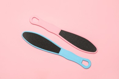 Photo of Colorful foot files on pink background, flat lay. Pedicure tools