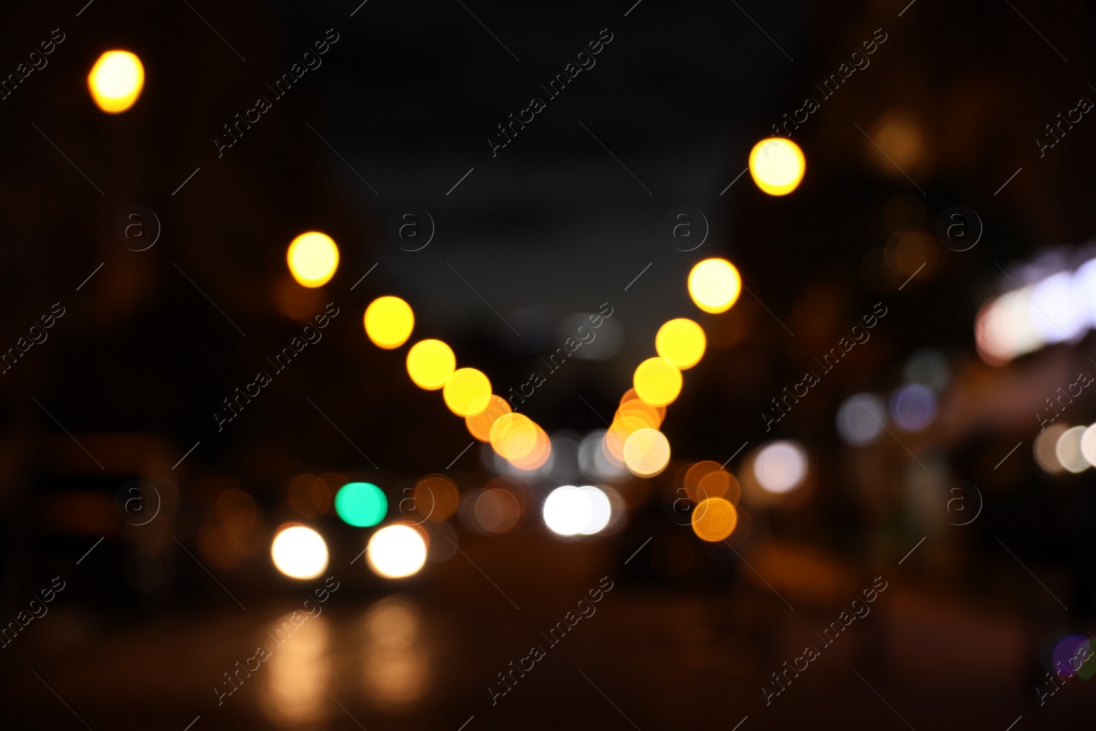 Photo of Blurred view of city street with lights at night. Bokeh effect