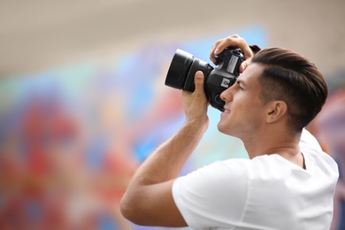 Photo of Photographer taking picture with professional camera outdoors