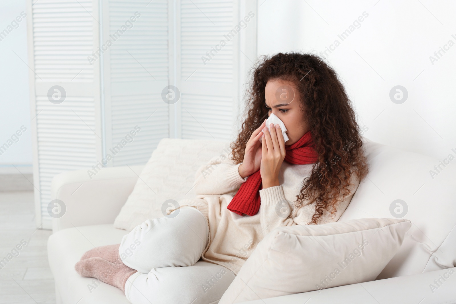 Photo of Sick African American woman with tissue at home, space for text