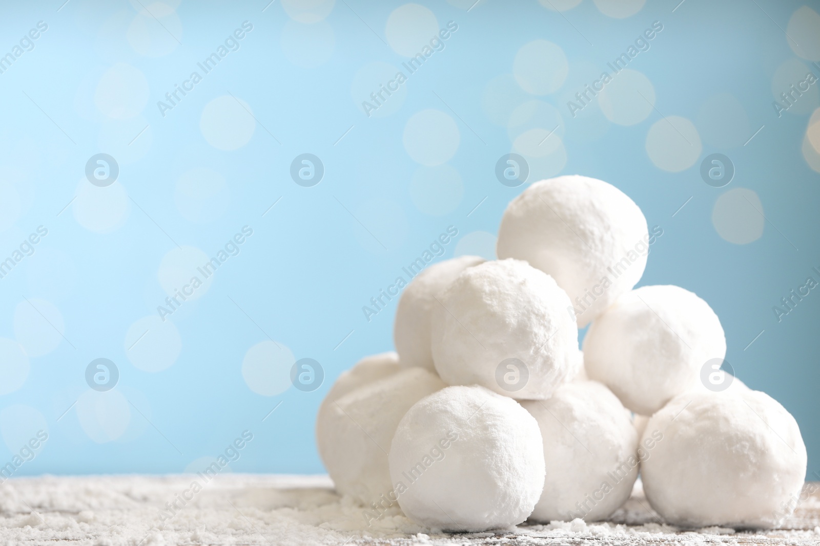 Photo of Snowballs on table against blurred lights, space for text