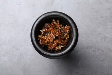 Photo of Modern hookah bowl with tobacco on grey table, top view