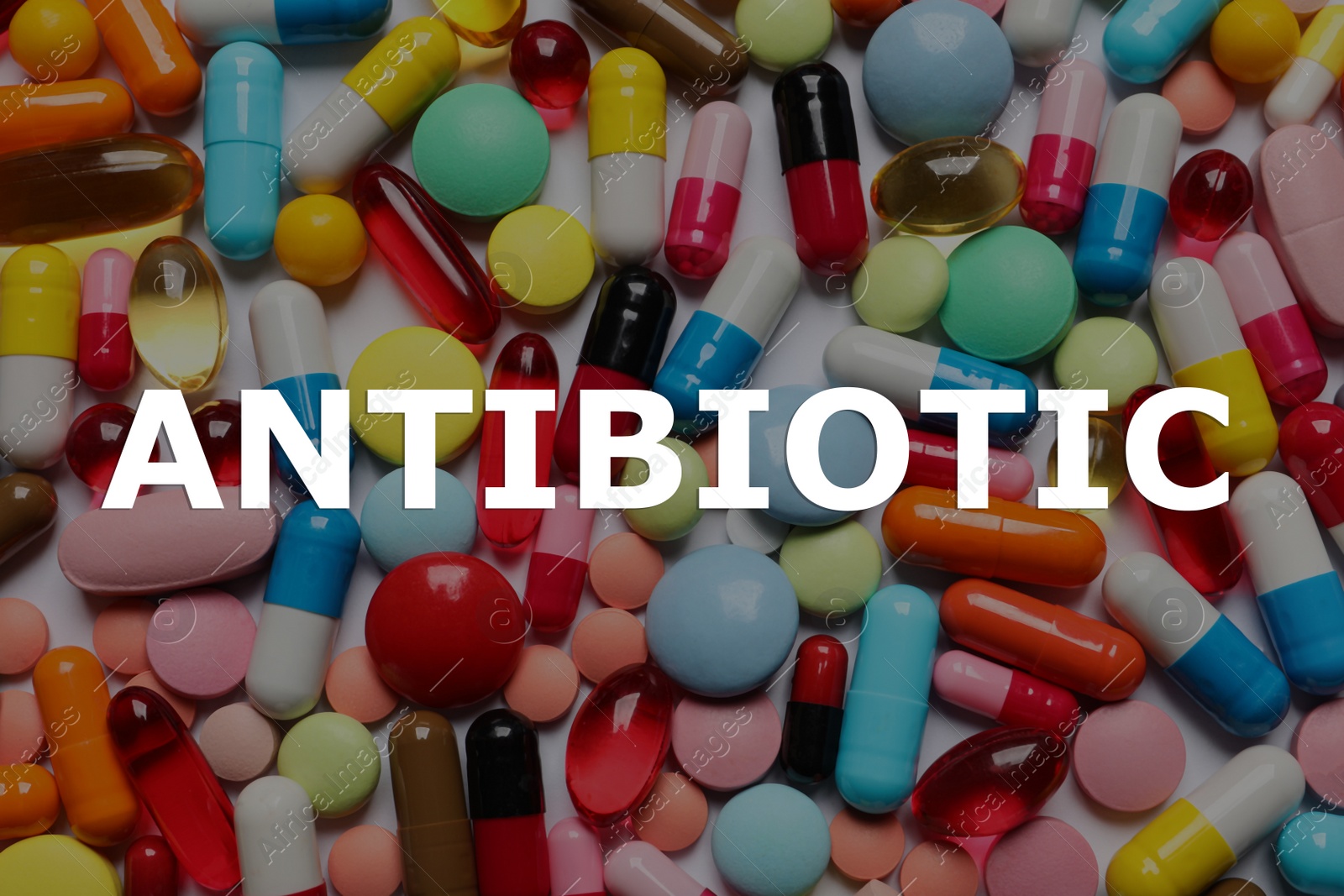 Image of Word Antibiotic and lots of different colorful pills as background, top view