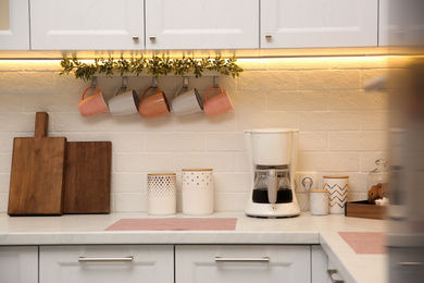 Photo of Stylish kitchen interior with modern coffeemaker on countertop