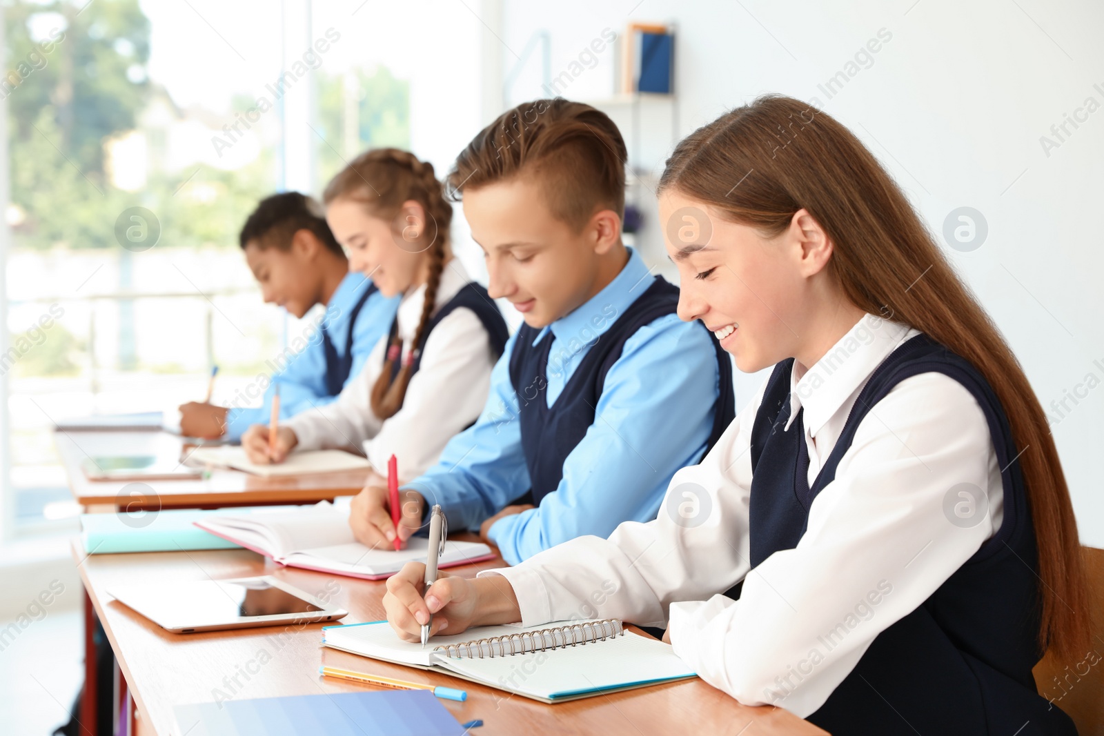 Photo of Teenage students in classroom. Stylish school uniform