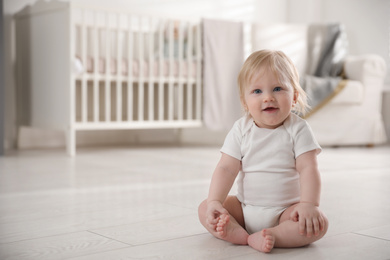 Photo of Cute little baby on floor at home