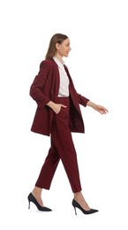 Young woman in burgundy suit walking on white background