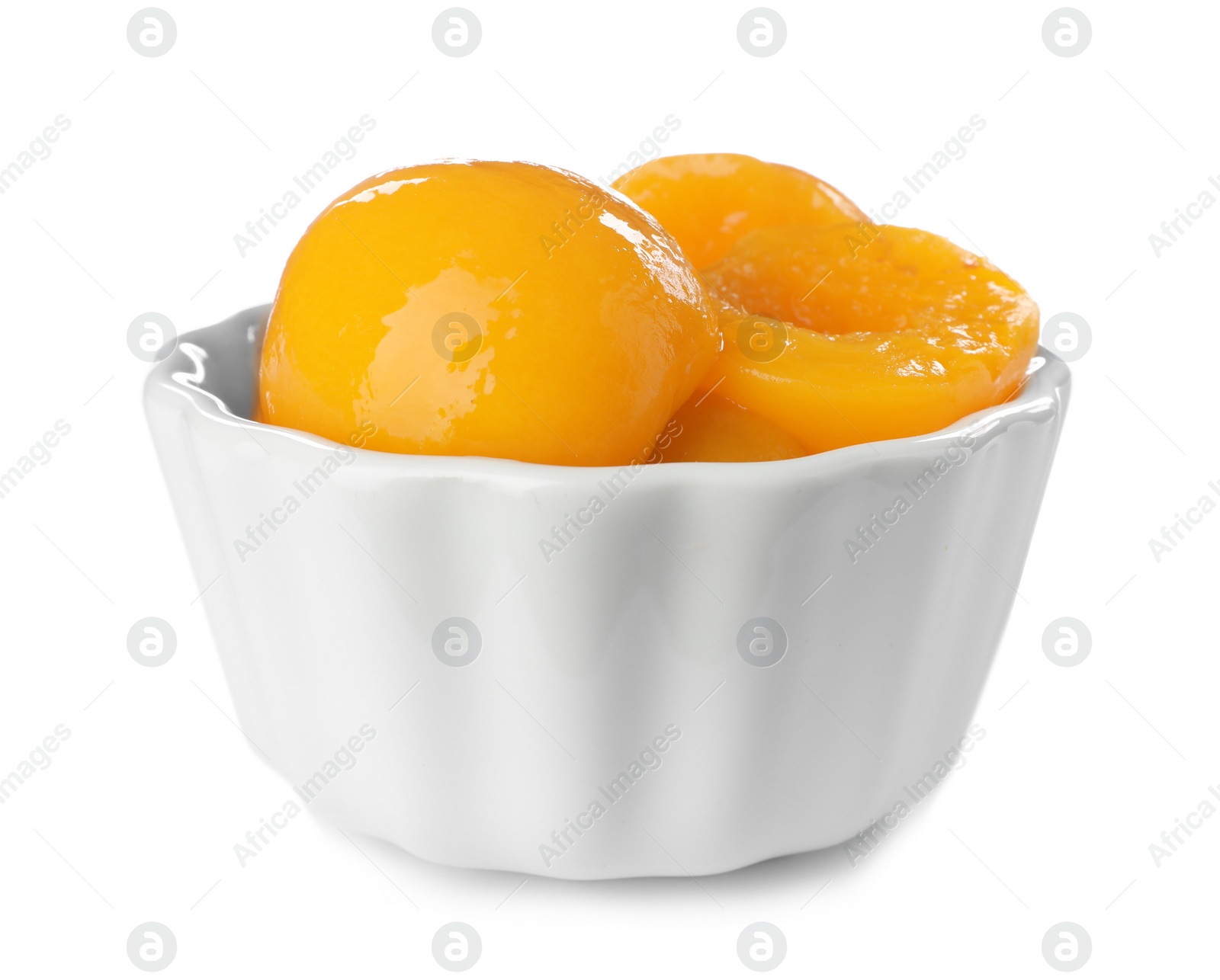 Photo of Bowl with halves of canned peaches on white background