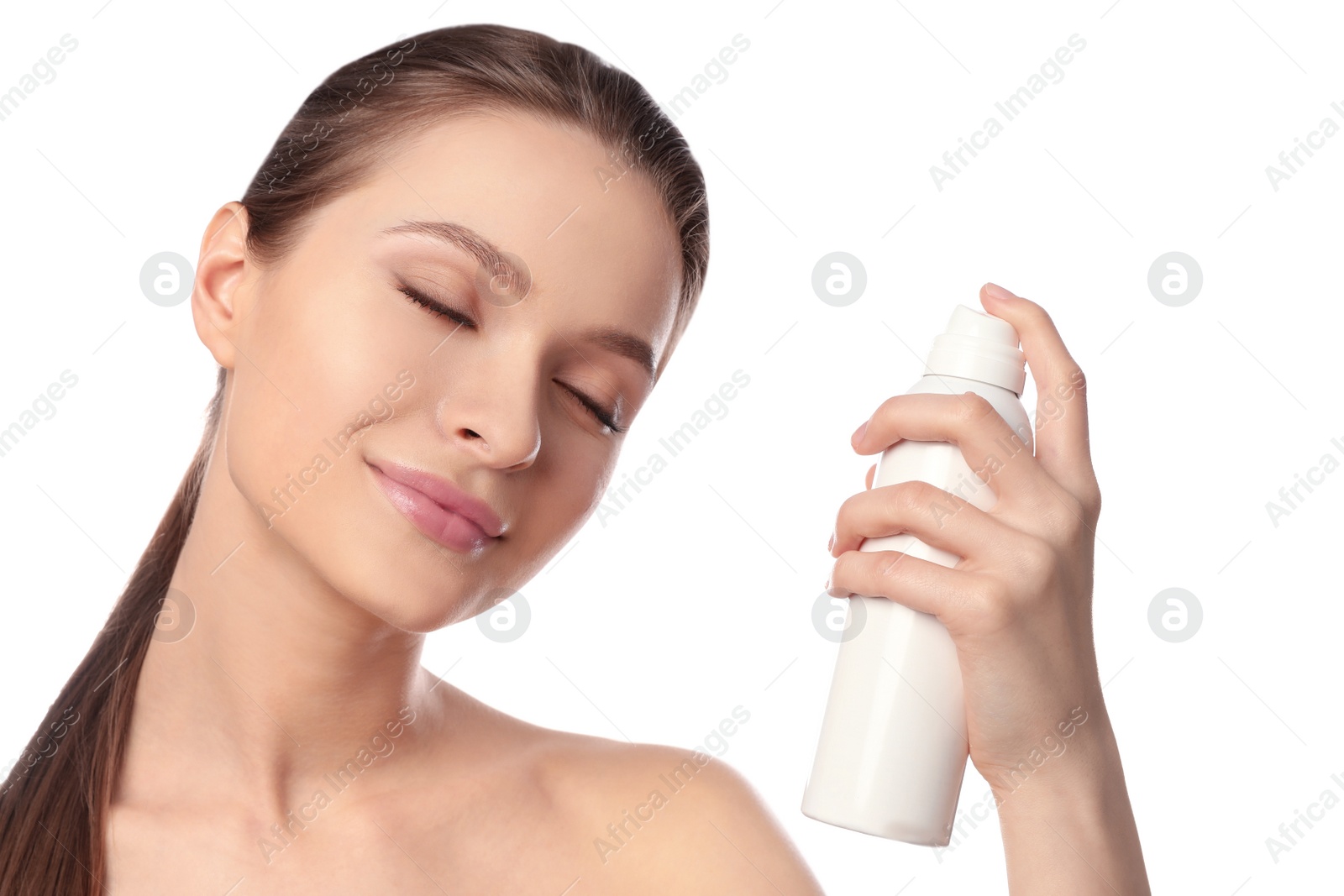 Photo of Young woman applying thermal water on face against white background. Cosmetic product