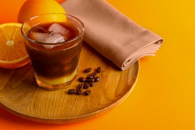 Photo of Tasty refreshing drink with coffee and orange juice on bright color background, space for text