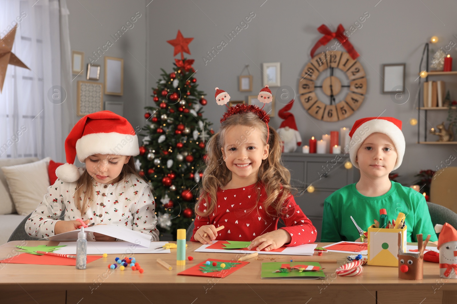 Photo of Cute little children making beautiful Christmas greeting cards at home