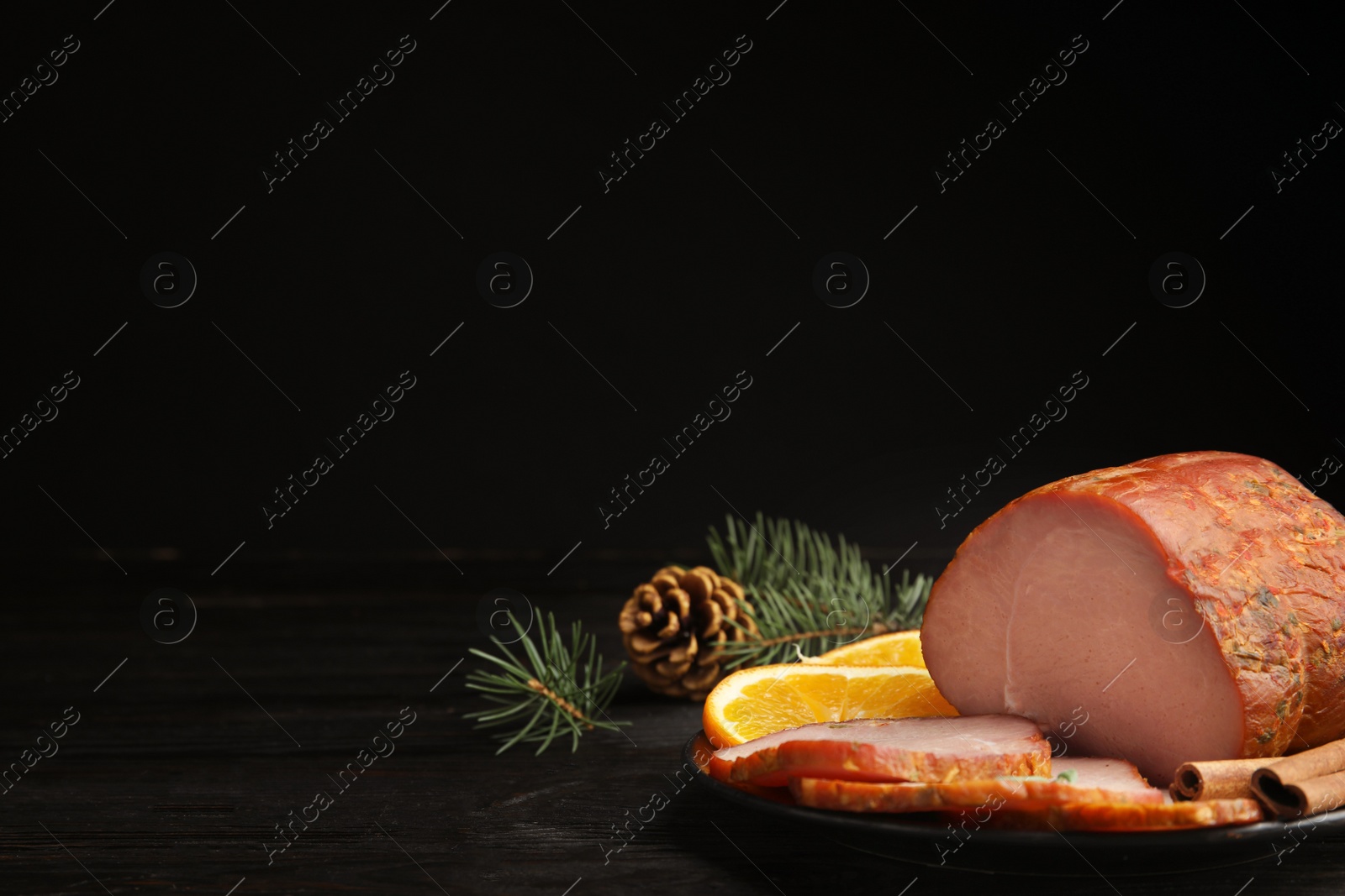 Photo of Delicious ham served on black wooden table, space for text. Christmas dinner