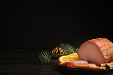 Photo of Delicious ham served on black wooden table, space for text. Christmas dinner