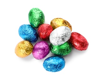 Chocolate eggs wrapped in colorful foil on white background, top view