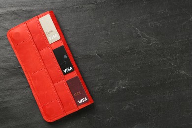 MYKOLAIV, UKRAINE - FEBRUARY 22, 2022: Wallet with Visa credit cards on black table, top view. Space for text