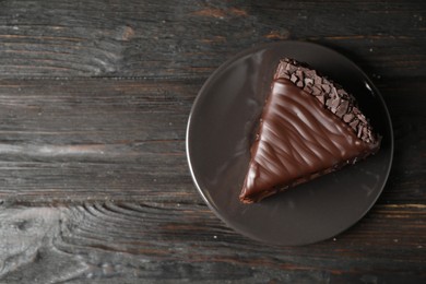 Photo of Delicious chocolate cake on black wooden table, top view. Space for text