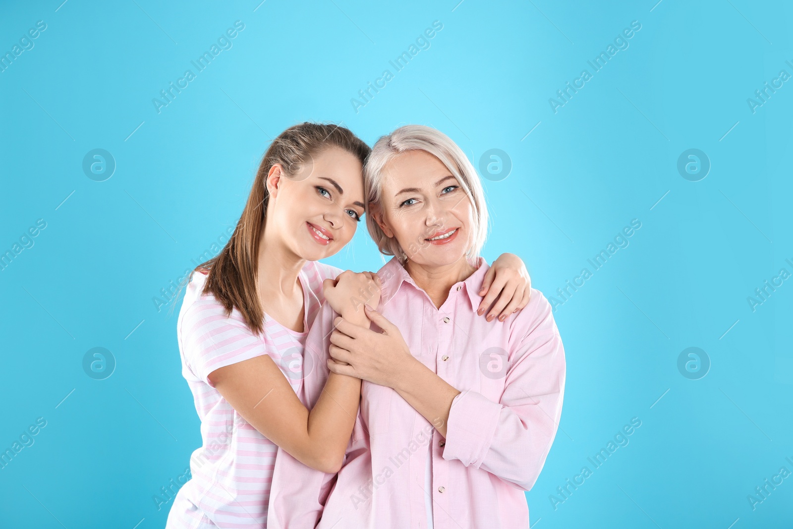 Photo of Portrait of young woman with her mature mother on color background