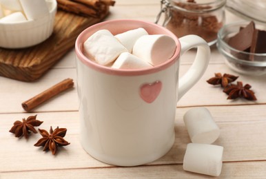 Tasty hot chocolate with marshmallows on white wooden table, closeup