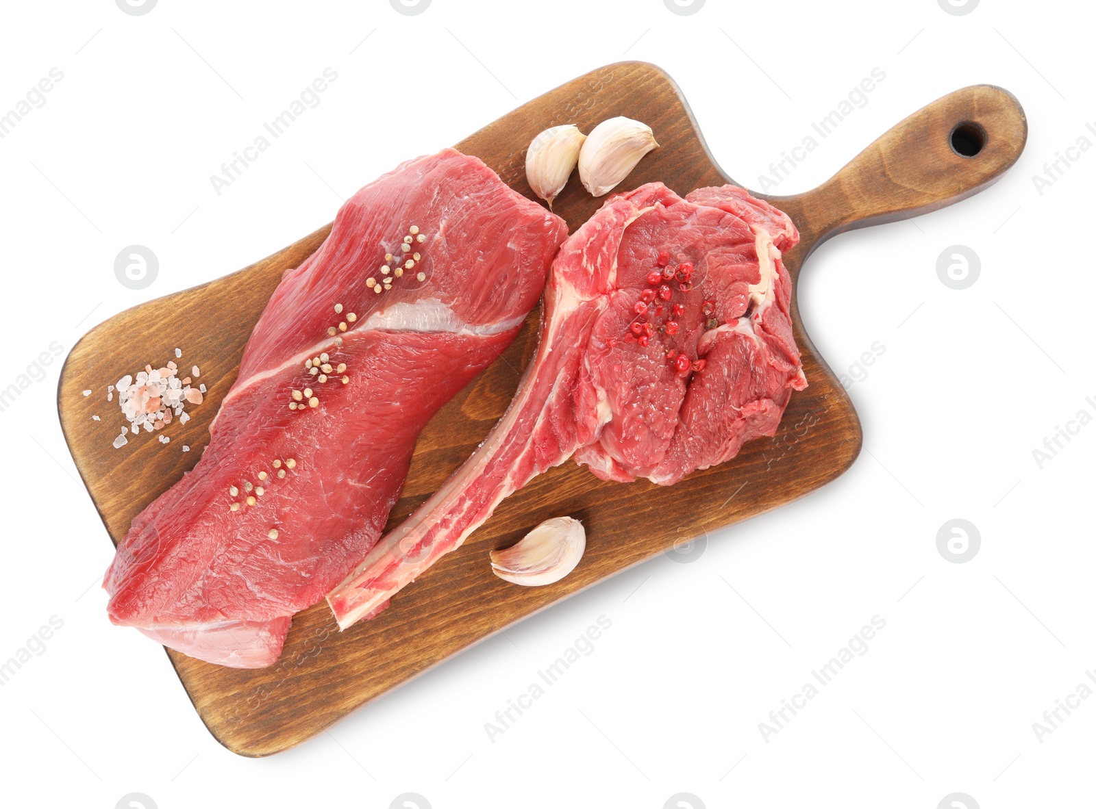 Photo of Board with pieces of raw beef meat and spices isolated on white, top view