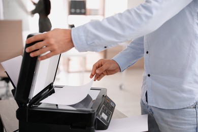 Employee using modern printer in office, closeup