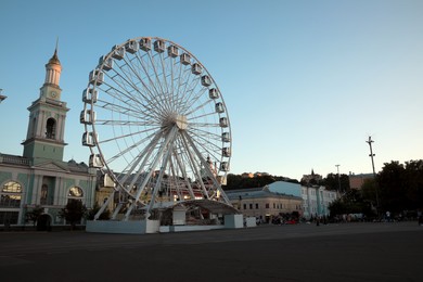 Photo of Big Ferris wheel on city street, low angle view. Space for text