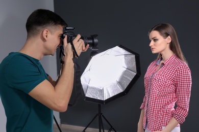 Photo of Beautiful young model posing for professional photographer in studio