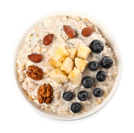 Photo of Tasty boiled oatmeal with blueberries, banana and nuts in bowl isolated on white, top view