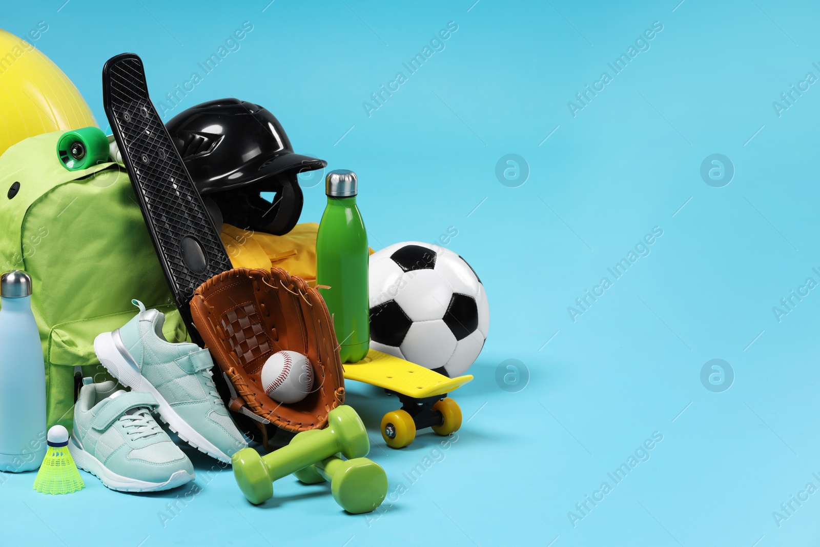 Photo of Many different sports equipment on light blue background, space for text