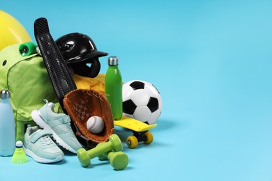 Many different sports equipment on light blue background, space for text