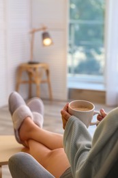 Photo of Woman with cup of aromatic coffee relaxing at home, closeup