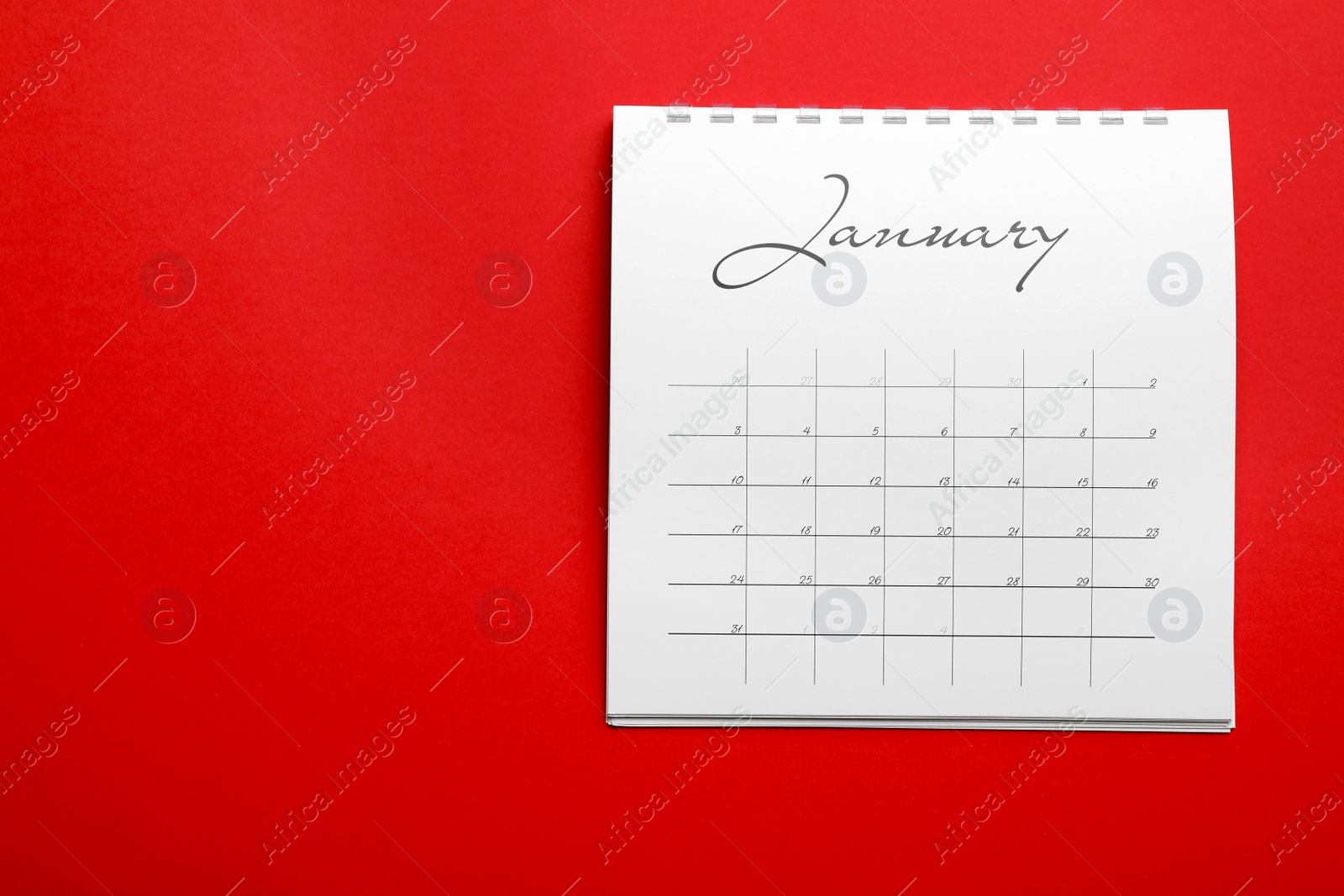 Photo of January calendar on red background, top view. Space for text