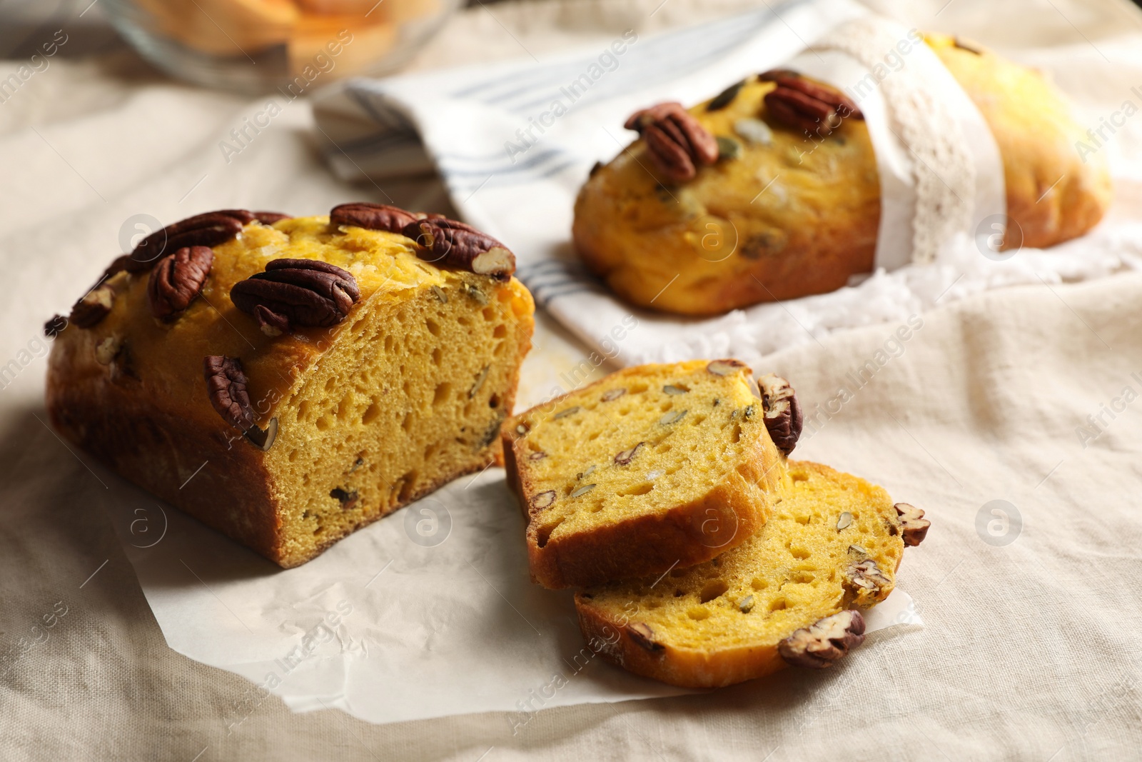 Photo of Delicious pumpkin bread with pecan nuts on tablecloth