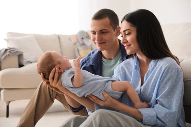 Photo of Happy family with cute baby near sofa at home