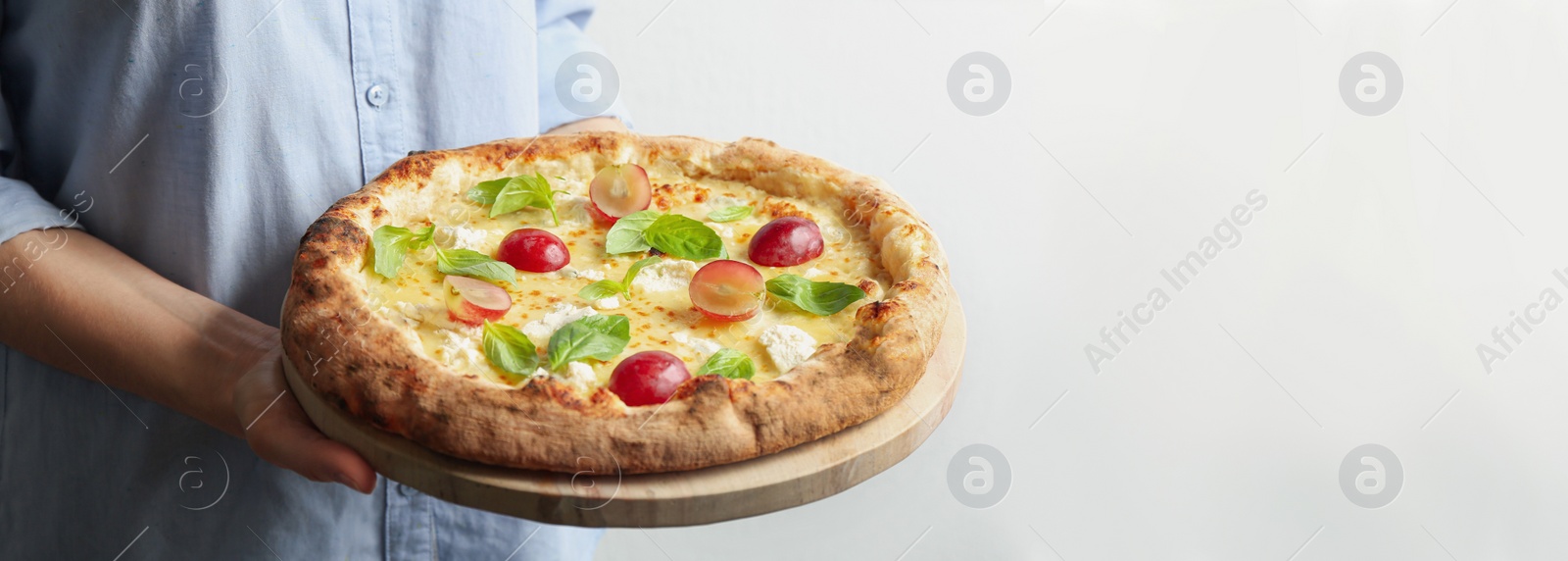 Image of Closeup view of woman holding delicious cheese pizza on white background. Banner design 