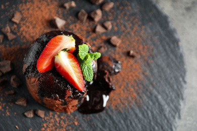 Photo of Delicious warm chocolate lava cake on slate board, above view. Space for text