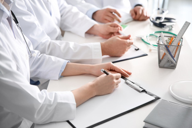 Doctors having meeting at table in office, closeup