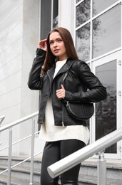 Beautiful young woman wearing stylish autumn clothes on city street