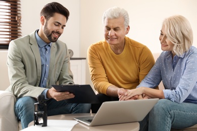 Male notary working with mature couple in office