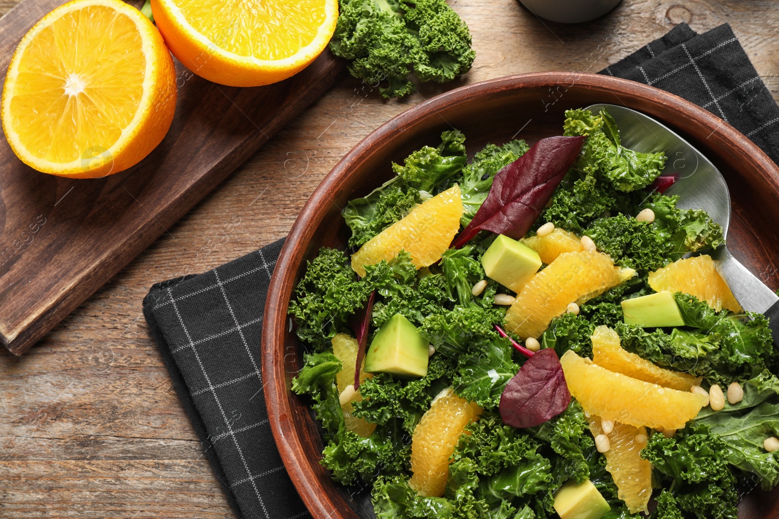 Photo of Tasty fresh kale salad on wooden table, flat lay