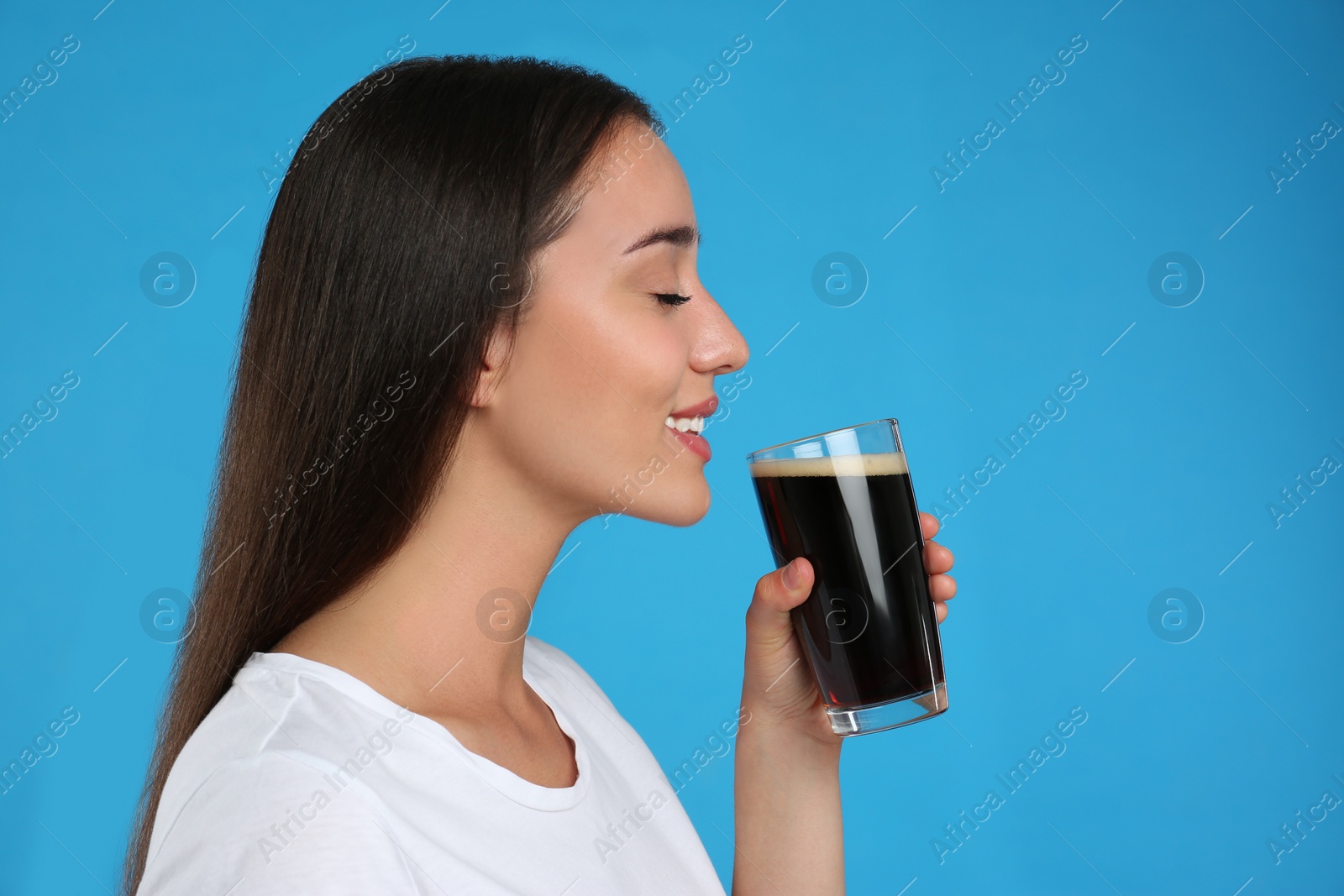 Photo of Beautiful woman with cold kvass on blue background. Traditional Russian summer drink