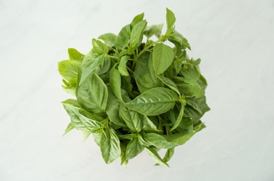 Fresh green basil in pot on white table, top view