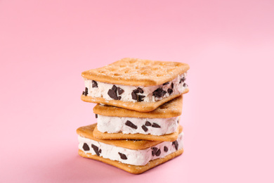 Photo of Sweet delicious ice cream cookie sandwiches on pink background