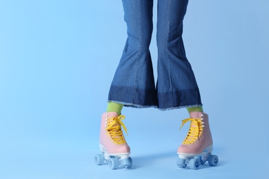 Photo of Woman with vintage roller skates on color background, closeup. Space for text