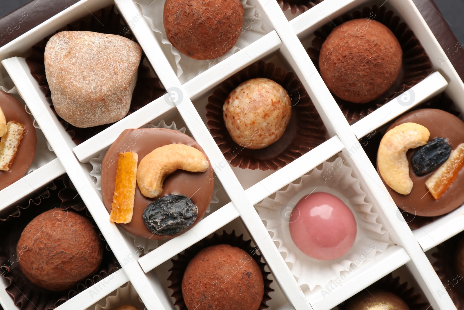 Photo of Different delicious chocolate candies in box, closeup