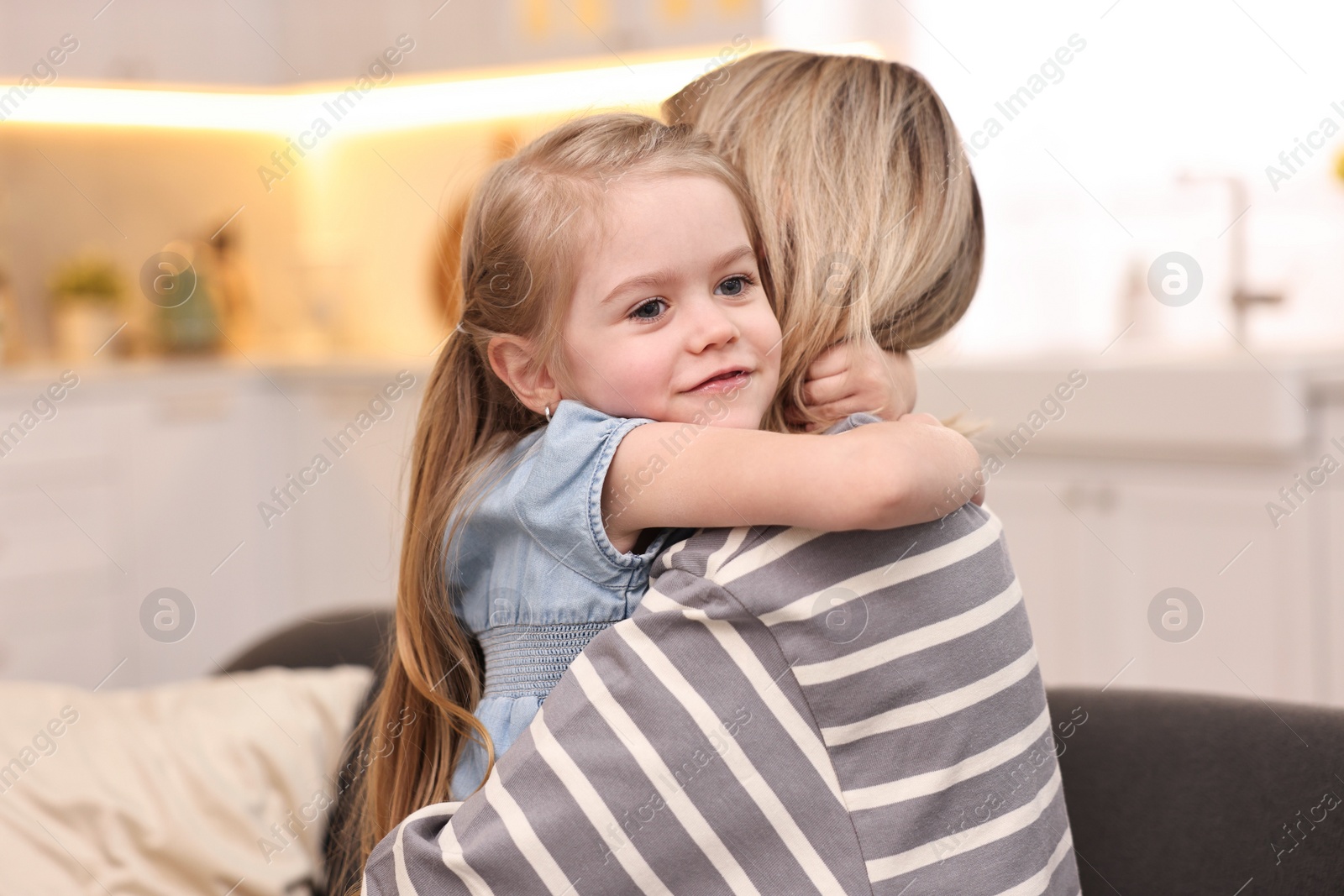 Photo of Cute little girl hugging her mom at home. Happy Mother's Day