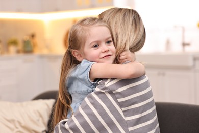 Cute little girl hugging her mom at home. Happy Mother's Day