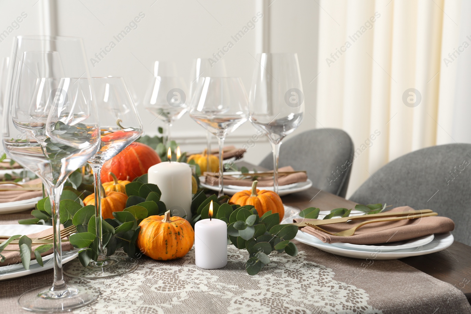 Photo of Beautiful autumn table setting. Plates, cutlery, glasses, pumpkins and floral decor