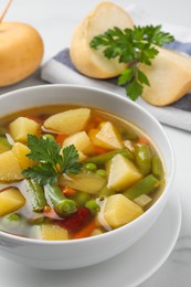 Photo of Bowl of delicious turnip soup on table, closeup