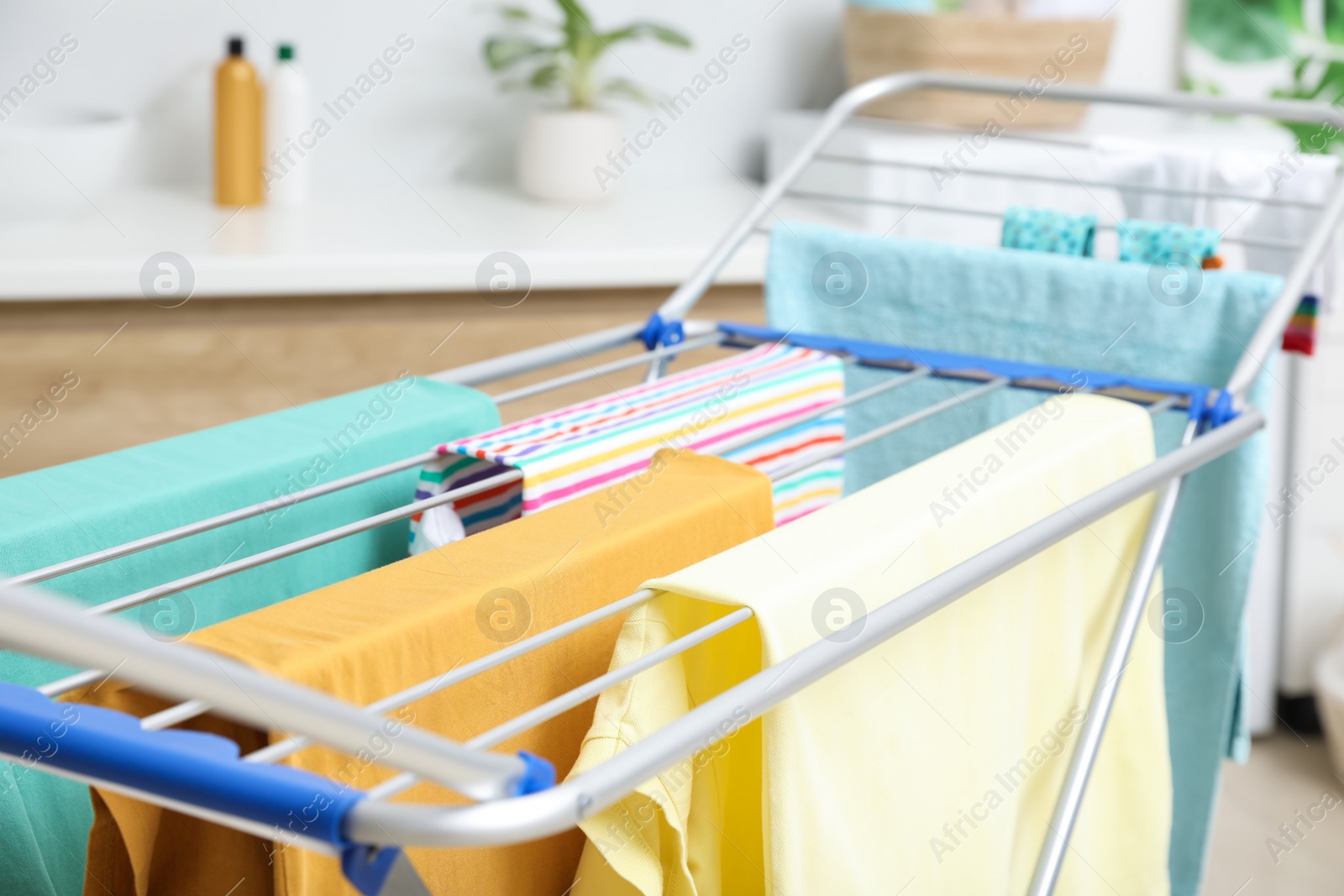 Photo of Clean laundry hanging on drying rack in bathroom, closeup