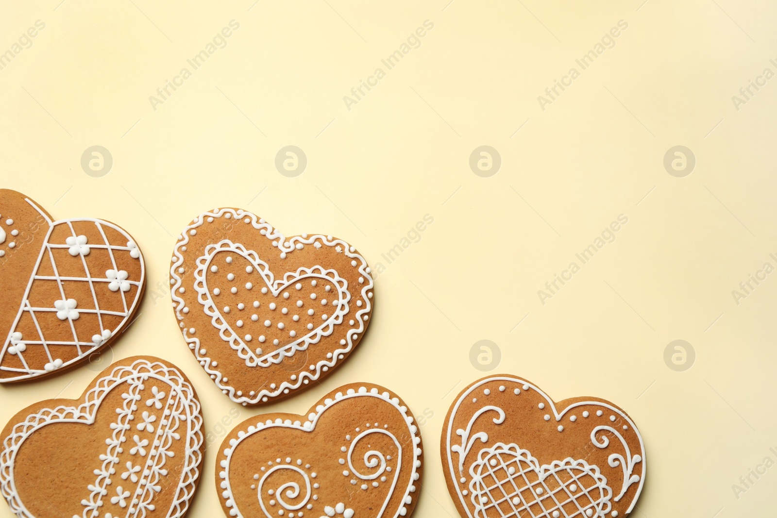 Photo of Tasty heart shaped gingerbread cookies on yellow background, flat lay. Space for text